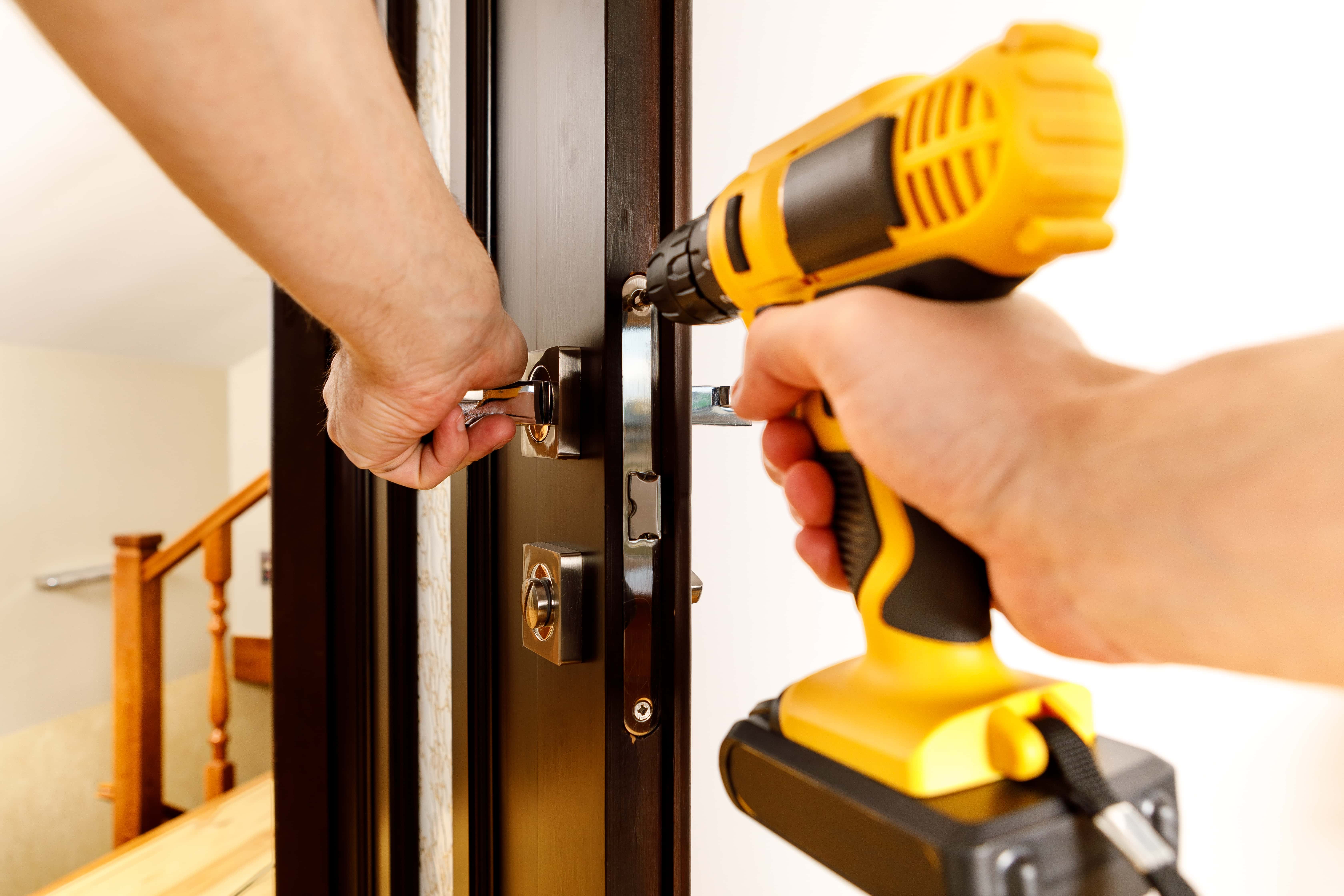 man repairing doorknob handyman repair door lock room